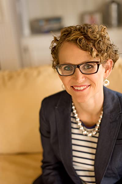 woman in navy blazers and glasses smiling for headshot