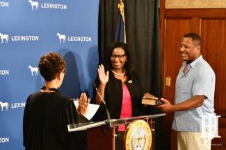 woman smiling while being sworn in as council member