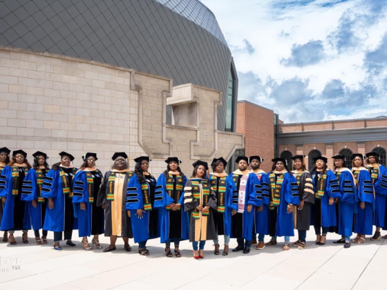 large group of Black doctoral graduates in graduation regalia 